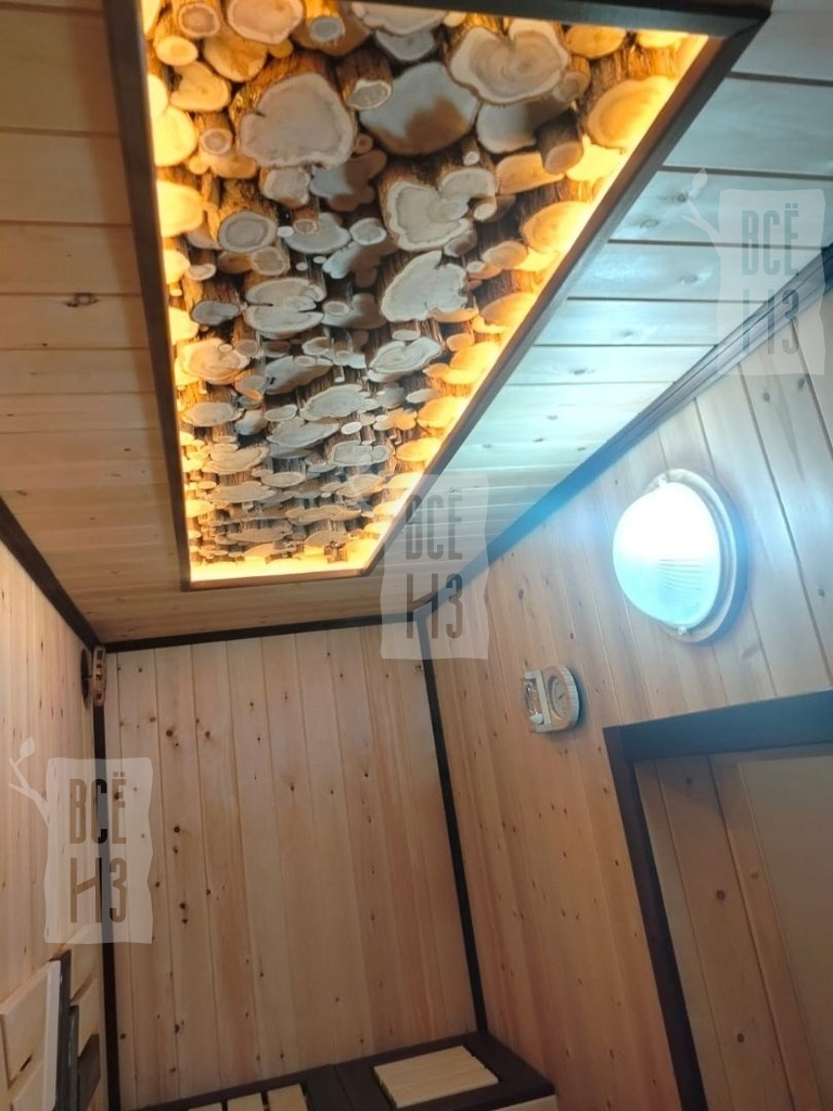 Интерьерное 3D панно из можжевельника с подсветкой для бани и сауны Фото интерьерного 3D панно из можжевельника с натуральной текстурой и подсветкой на потолке парной, создающего уютный и стильный декор в бане.